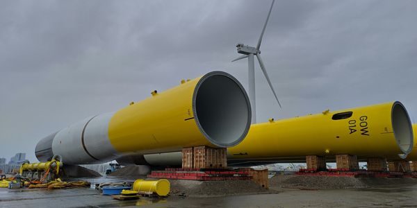 Yellow and white wind turbine towers waiting to be installed