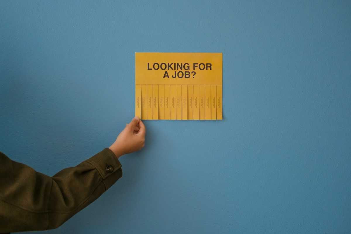 Yellow job posting "LOOKING FOR A JOB?" with tear-off phone number strips